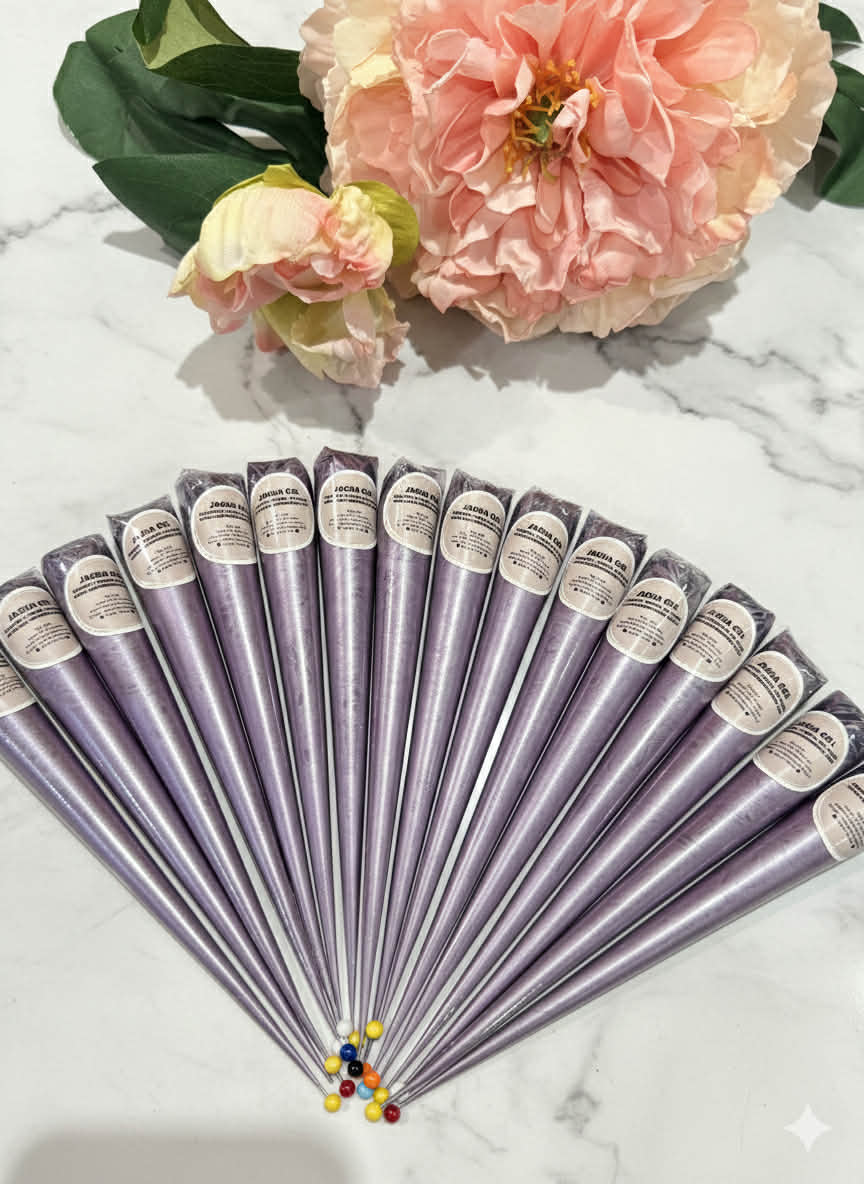 Lavender henna cones fanned out on marble with pink flowers, used for body art designs