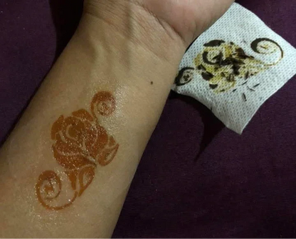 Henna rose floral design on forearm with tissue removing dried henna, body art