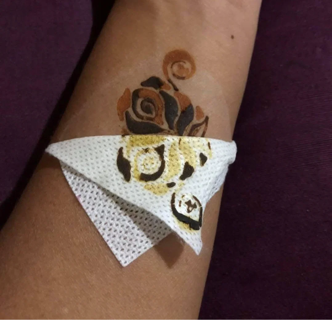 Rose floral henna design on forearm with tissue protecting fresh mehndi art