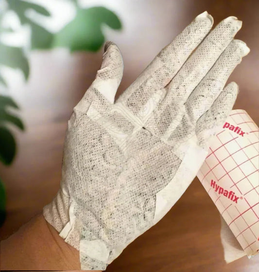 Hand covered in breathable adhesive wrap for henna protection, showing Hypafix tape
