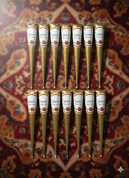Henna cones arranged on a patterned background, labeled for natural henna artwork.