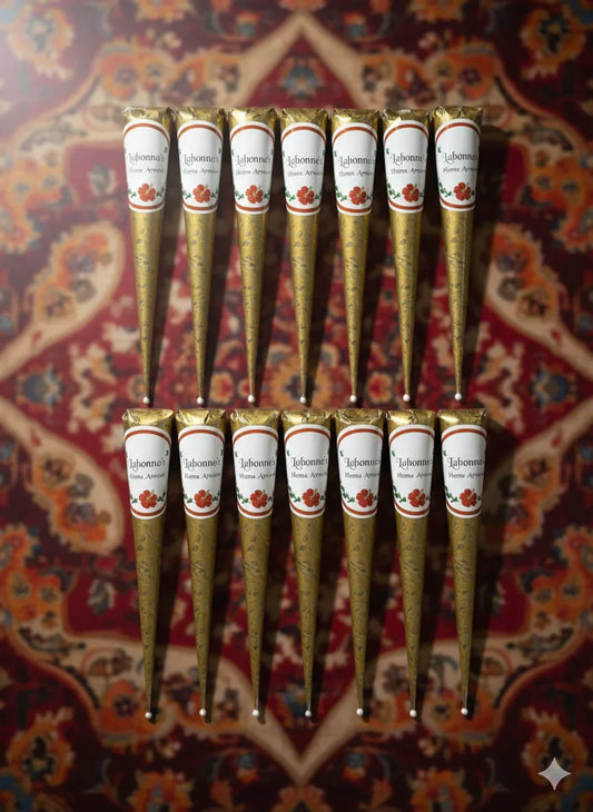 Henna cones arranged on a patterned background, labeled for natural henna artwork.